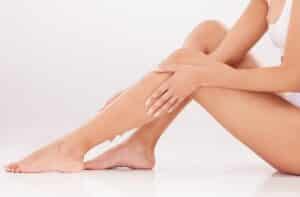 Woman touches her smooth legs after waxing