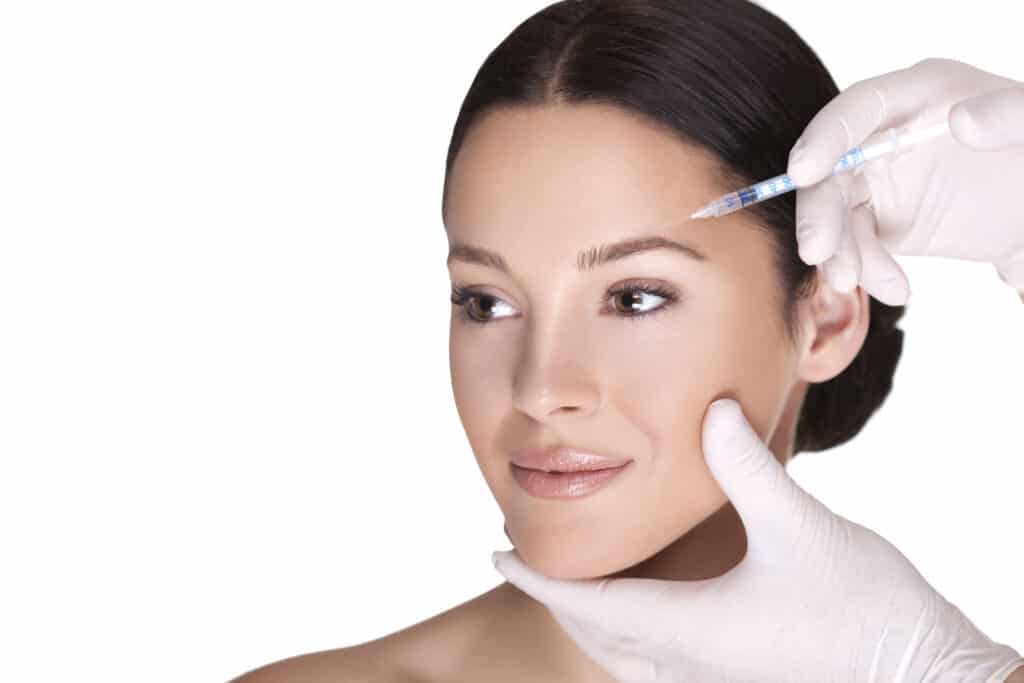 Woman glances to the side and smiles during a Daxxify injection for wrinkles in Lakeland
